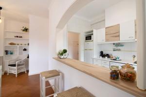 a kitchen with white cabinets and a wooden counter top at Apartamento Medusa by Sunnyway in Olhos de Água