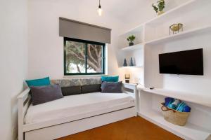 a living room with a couch and a flat screen tv at Apartamento Medusa by Sunnyway in Olhos de Água
