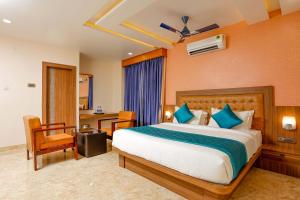 ein Schlafzimmer mit einem großen Bett, einem Schreibtisch und einem Stuhl in der Unterkunft HOTEL TAIKA in Rāmeswaram