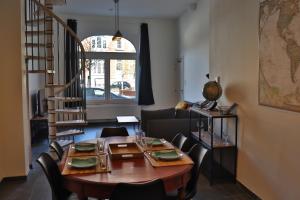 sala de estar con mesa de madera y sillas en Le Patenier en Dinant