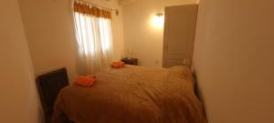 een slaapkamer met een bed met 2 oranje kussens erop bij DEPARTAMENTO EN LA MONTAÑA in Ushuaia