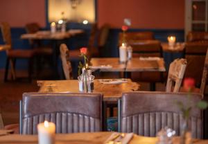 um restaurante com mesas de madeira e cadeiras com velas em Black Bull em Lauder