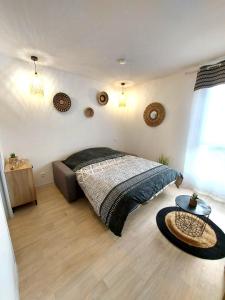 a bedroom with a large bed and a table at L'ETHNIK--STUDIO TOUT CONFORT--CLIM--PARKING--WIFi in Lourdes