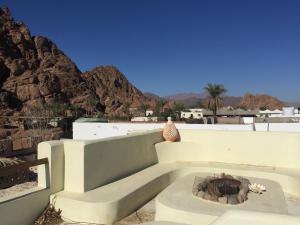 eine Außenterrasse mit einer Feuerstelle und Bergen in der Unterkunft Sinai Old Spices B&B in Sharm El Sheikh
