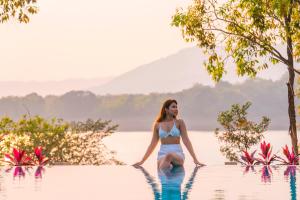 una mujer en bikini sentada en el agua en una piscina en Zostel Plus Lonavala, en Lonavala
