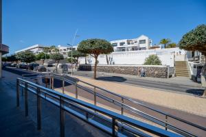een stadsstraat met een hellingbaan en een trottoir met gebouwen bij Bimba's in Puerto del Carmen
