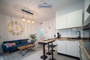 a kitchen and a living room with a blue couch at Apartamento Diego Benitez in Sanlúcar de Barrameda