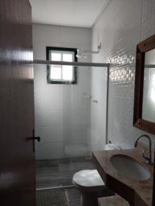 y baño con aseo, lavabo y ducha. en Casa Rio de Contas en Rio de Contas