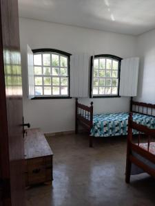 a bedroom with two beds and two windows at Casa Rio de Contas in Rio de Contas