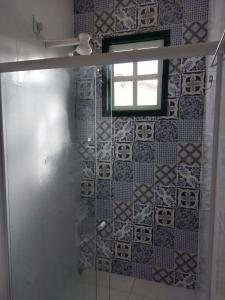a bathroom with a window and a tiled wall at Casa Rio de Contas in Rio de Contas