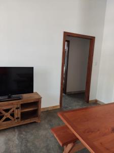 a living room with a flat screen tv and a table at Casa Rio de Contas - Renovada e Ampliada in Rio de Contas