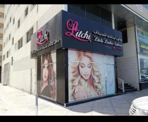 a building with a sign for a hair salon at Entire Studio Flat in Sharjah. in Sharjah