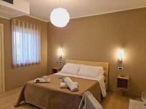 a bedroom with a large bed with a light at Hotel La Campagnola in Capo Vaticano