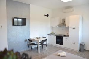 a small kitchen with a table and chairs in a room at Studio apartman Gili in Kaštela