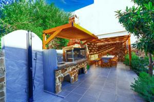 a patio with a stone grill with a table and chairs at Bitsakis Family - Paleochora Luxury Villa in Palaiochóra +60 photos