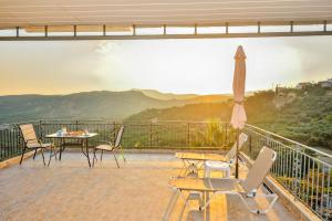 balcón con mesa, sillas y sombrilla en Cretan Nature, en Kissamos