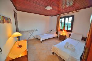 1 dormitorio con 2 camas y mesa con lámpara en Cretan Nature, en Kissamos