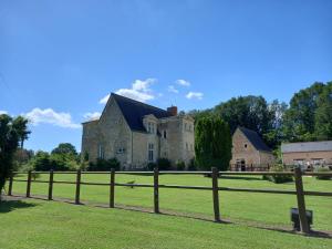 une clôture devant une grande maison dans l'établissement Logis de Poëllier, à Baugé