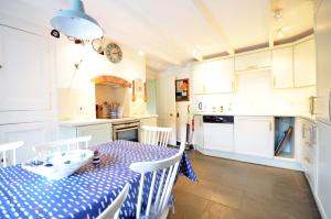 a kitchen with a table with a blue and white table cloth at Westover, St Mawes in Saint Mawes