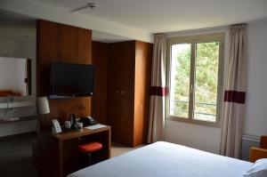 a hotel room with a bed and a window at Domaine de Frémigny in Bouray-sur-Juine