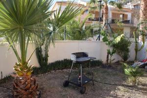 a barbecue grill in a garden with palm trees at Luxury 1 bedroom private apartment - Dog friendly! in Finestrat