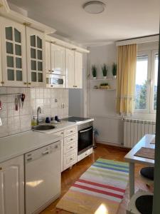 a kitchen with white cabinets and a sink at Rustik Senjak in Sajmište