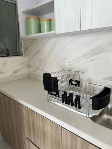 a kitchen counter with a dish drying rack on the counter at Apartamento agradable para disfrute y relajación in Girardot