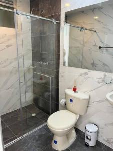 a bathroom with a toilet and a glass shower at Apartamento agradable para disfrute y relajación in Girardot