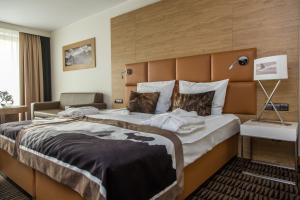 ein Hotelzimmer mit einem großen Bett und einem Sofa in der Unterkunft Rezydencja Nosalowy Dwór in Zakopane