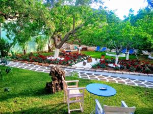 a yard with a chair and a table and flowers at Villa Emilia in Pachis