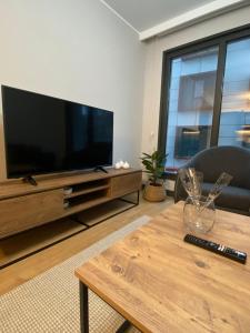 een woonkamer met een grote televisie en een salontafel bij Central Modern Apartment by Siena Suites in Istanbul