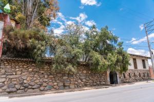 a stone wall with trees on the side of a street at Casona Museo Catalina Huanca in Huancayo