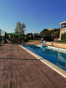 uma piscina com um deque de madeira ao lado de um edifício em LOS PRUNOS em Maello