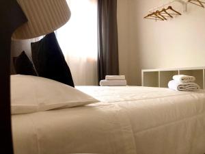 Un dormitorio con una cama blanca con toallas. en CapoAlessio, en SantʼAlessio Siculo