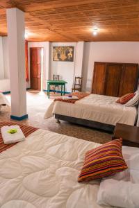 Cette chambre comprend 2 lits et une table. dans l'établissement Casona Museo Catalina Huanca, à Huancayo