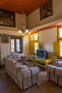a living room with couches and a tv at Casona Museo Catalina Huanca in Huancayo