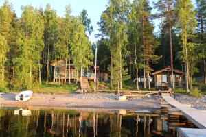 a cabin in the woods next to a lake at Villa by the Lake in Joutseno