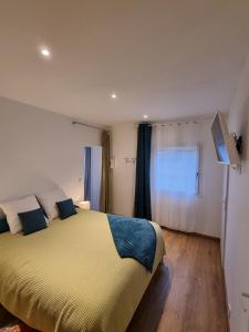 Un dormitorio con una cama amarilla y una ventana en Les Tables Aux Vaches - Maison d'Hôtes - Table d'Hôtes sous conditions, en La Salvetat-sur-Agout