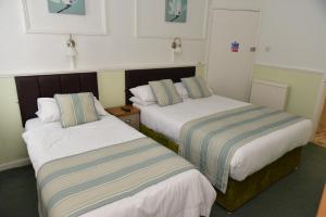 2 camas en una habitación de hotel con aceras en CORBIERE GUEST HOUSE, en Weston-super-Mare