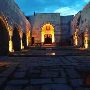 an empty courtyard in a building with lights at Akhan Kervansaray Hotel in Eskihisar