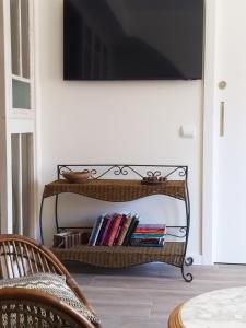 un estante de libros con libros y un televisor en una pared en Arrels apartaments en L'Ampolla