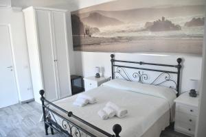 1 dormitorio con 1 cama con 2 toallas en Angelique Affittacamere, en Santa Teresa Gallura