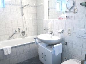 ein Badezimmer mit einem Waschbecken, einem WC und einer Badewanne in der Unterkunft Pension Katrin in Salzburg