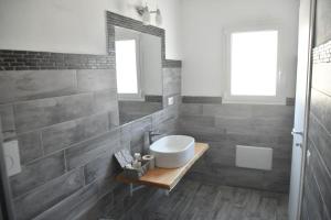 a bathroom with a sink and a mirror at Angelique Affittacamere in Santa Teresa Gallura