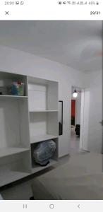 a living room with white shelves in a room at Casa em Villagio em Boracéia próximo a praia. in Bertioga