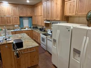 Una cocina con electrodomésticos blancos y gabinetes de madera. en Lodge on Lake Godstone, en Jacksboro
