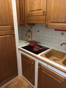una cucina con mobili in legno, una stufa e un lavandino di Scacciapensieri house a Nettuno Altre 24 foto