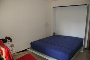 ein Schlafzimmer mit einem blauen Bett in einem Zimmer in der Unterkunft Casa Paggi in Lavagna