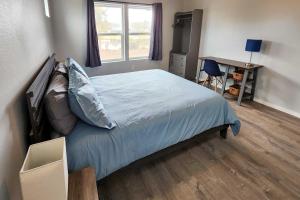 a bedroom with a bed and a desk and a window at Canal Cottage Retreat with Dock and Waterfront Views in Ocean Shores