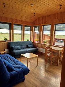 sala de estar con sofá y mesa en Bright and Peaceful Cabin with Views & Hot Tub, en Selfoss